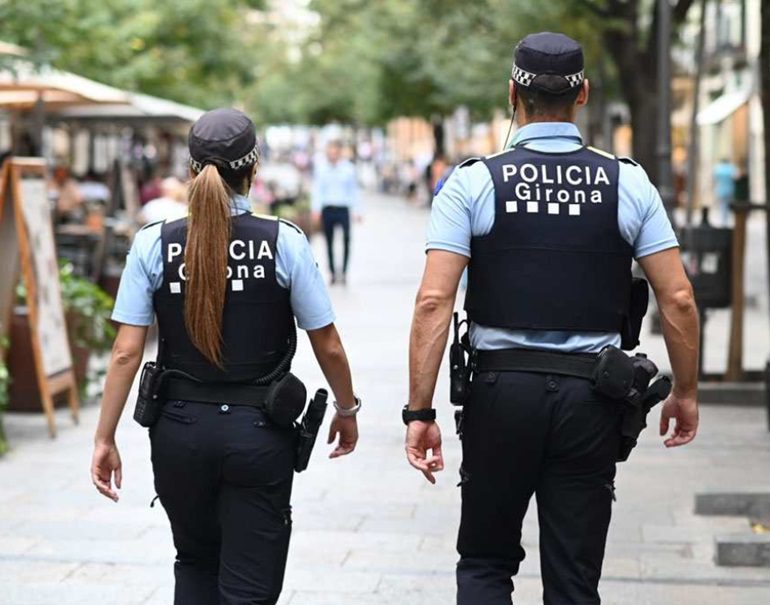 Binomio de la Policía Municipal de Girona patrullando a pie por las calles de la ciudad.