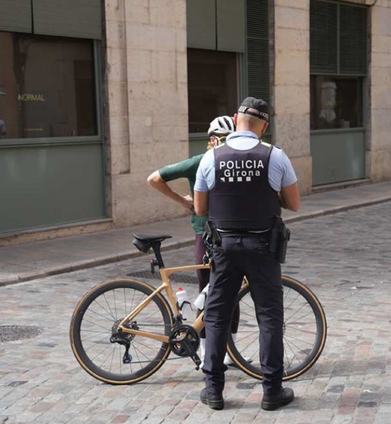 Agente de la Policía Municipal de Girona hablando con un cicloturista